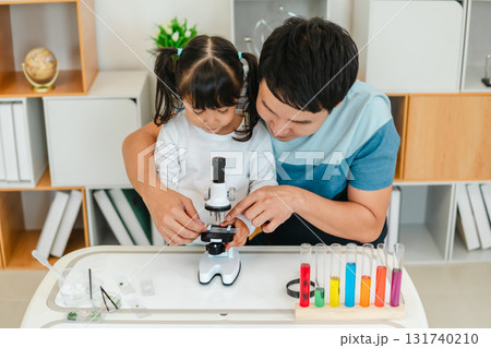 father and toddler girl scientist placing microscope slides with specimen. learning science 131740210