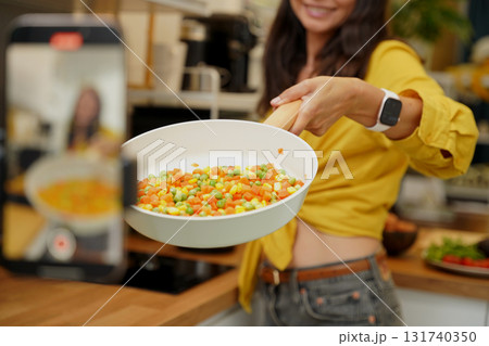 Young woman is broadcasting live from workshop how to prepare a vegetarian food Young woman is broadcasting live from workshop how to prepare a vegetarian food 131740350