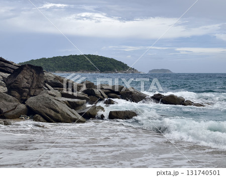 A tranquil beach scene featuring gentle waves lapping against rocks A tranquil beach scene featuring gentle waves lapping against rocks 131740501