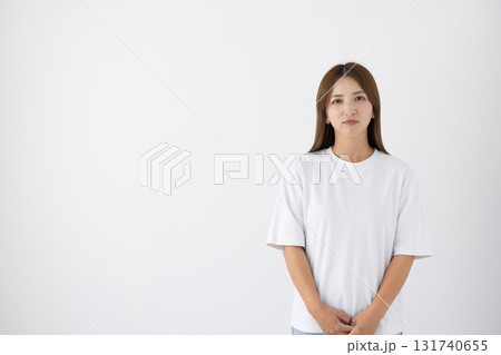 白い背景の前でシリアスな表情をする若い女性 131740655