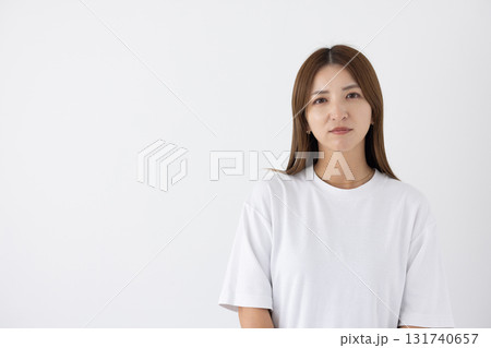 白い背景の前でシリアスな表情をする若い女性 白い背景の前でシリアスな表情をする若い女性 131740657
