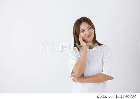 白い背景の前で笑顔を見せる若い女性 白い背景の前で笑顔を見せる若い女性 131740734