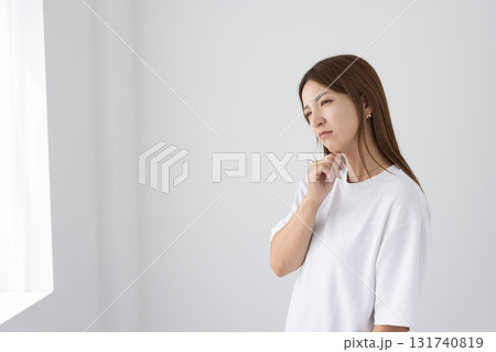 明るい部屋の中で困った表情を浮かべる若い女性 131740819