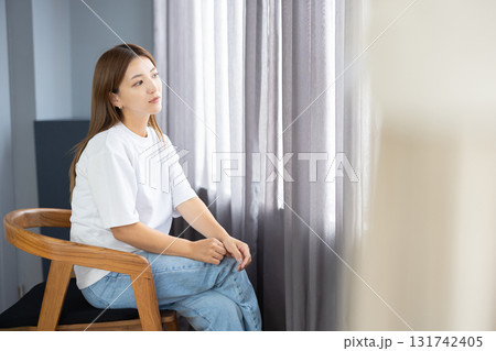 椅子に座って物思いにふける若い女性 131742405