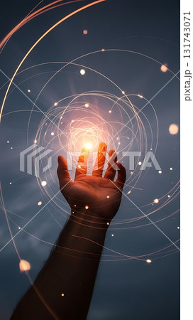 Hand reaching towards glowing orb surrounded by swirling light strands 131743071