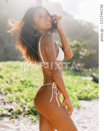 Elegant woman in bikini posing on sandy beach with sunshine Elegant woman in bikini posing on sandy beach with sunshine 131744156