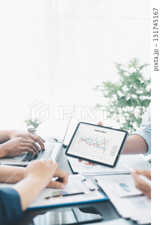 Business data analysis concept with colleagues reviewing financial report on tablet, pointing at chart with growth graph, teamwork discussing statistics, planning strategy and corporate success. Business data analysis concept with colleagues reviewing financial report on tablet, pointing at chart with growth graph, teamwork discussing statistics, planning strategy and corporate success. 131745167