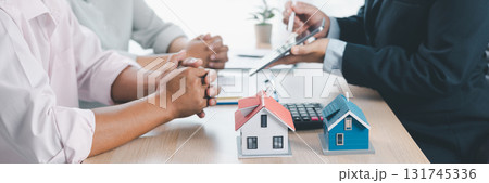 Mortgage consultation panorama with miniature house model in hand, financial advisor meeting clients, property investment, home loan agreement, real estate planning and housing business negotiation. 131745336