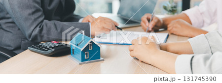 Panorama view of business meeting with miniature house model on desk, real estate contract signing, property investment, mortgage loan agreement and financial planning concept. mortgage loan agreement Panorama view of business meeting with miniature house model on desk, real estate contract signing, property investment, mortgage loan agreement and financial planning concept. mortgage loan agreement 131745390