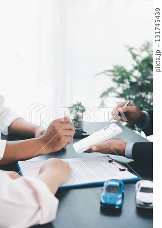 Businessman explaining car loan agreement with calculator, customer discussing auto finance deal at office desk with toy car and document, concept of vehicle loan, insurance or car leasing. car loan. Businessman explaining car loan agreement with calculator, customer discussing auto finance deal at office desk with toy car and document, concept of vehicle loan, insurance or car leasing. car loan. 131745439