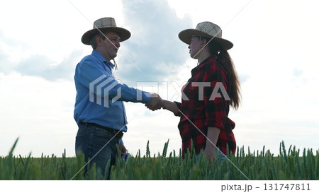 Business deal in wheat field, Successful partnership handshake, Mens handshake in the country, Agreement on agricultural business, Farming cooperation under the sky, Rural deal and negotiation 131747811