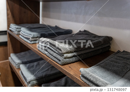 Stack of folded towels on shelf in public locker room 131748097