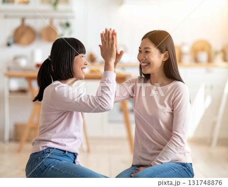 家庭でハイタッチするお母さんと子供 家庭でハイタッチするお母さんと子供 131748876