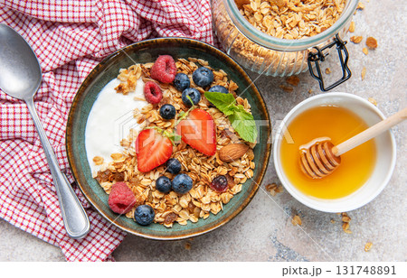 Granola yogurt parfait with fresh berries and honey 131748891