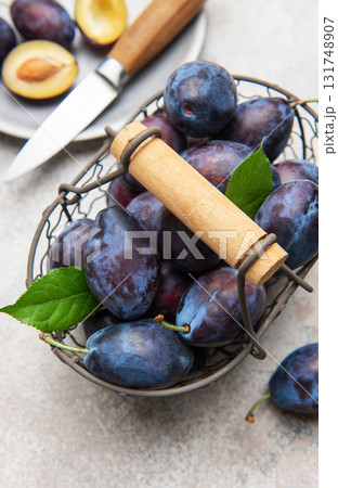 Fresh plums in basket with sliced fruit Fresh plums in basket with sliced fruit 131748907