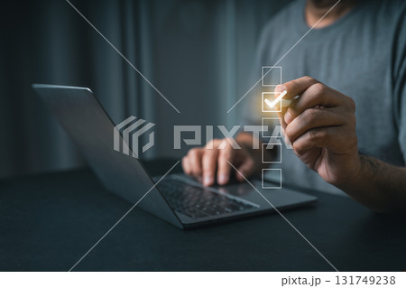 Close-up businessman hand User Interacting with Digital Checklist on Laptop Screen, Concept of Task Management, Productivity, Remote Work, and Organization in Modern Life 131749238