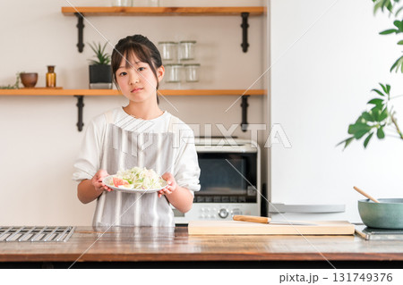 キッチンで野菜を持つ子供・女の子・キッズ（困る・野菜嫌い・好き嫌い） 131749376