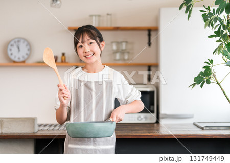 家のキッチンにいるエプロン姿の小学生・中学生の女の子 131749449