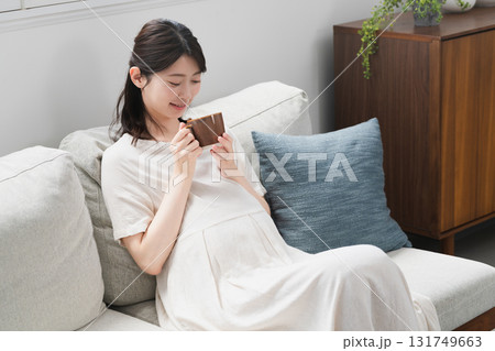 ソファーで飲み物を飲む妊婦 ライフスタイルイメージ ソファーで飲み物を飲む妊婦 ライフスタイルイメージ 131749663