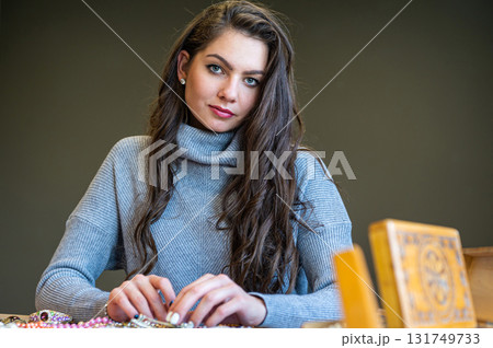 reflection of a woman in mirror choosing and trying different jewelry, soft focus, closeup 131749733