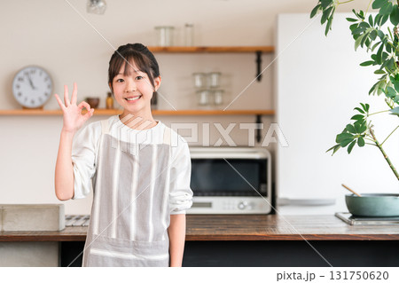 家のキッチンにいるエプロン姿の小学生・中学生の女の子 131750620