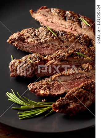 Grilled beef steak on a black plate. 131750654