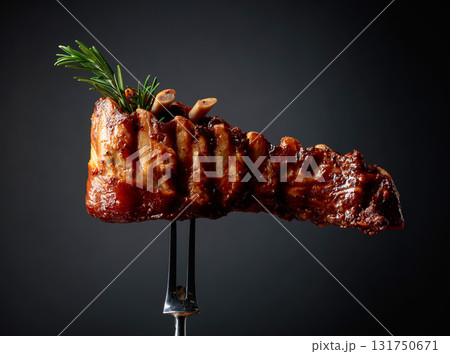 Grilled pork ribs with rosemary on a fork. 131750671