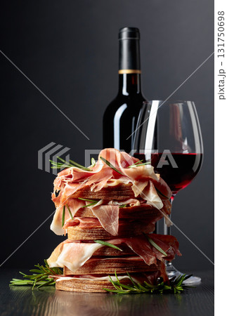 Spanish jamon or Italian prosciutto with bread, rosemary, and red wine. Spanish jamon or Italian prosciutto with bread, rosemary, and red wine. 131750698