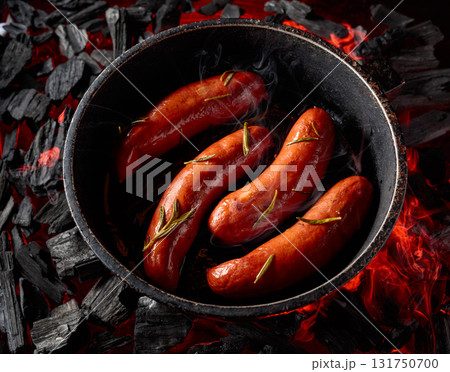 Roasted Bavarian sausages with rosemary on a burning charcoal. Roasted Bavarian sausages with rosemary on a burning charcoal. 131750700
