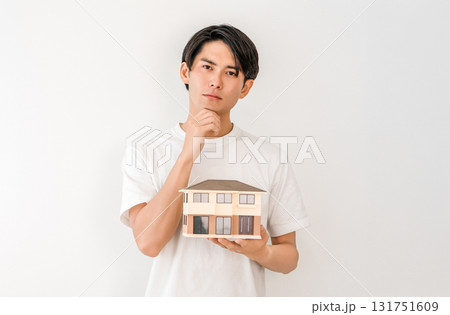 住宅模型を持つ若いアジア人男性（マイホーム,一戸建て,家づくり,考える,困る） 131751609