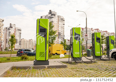 Green electric vehicle charging stations in urban residential area with modern buildings Green electric vehicle charging stations in urban residential area with modern buildings 131752452