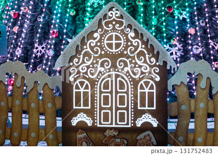 Festive gingerbread house with icing and decorated lights for holiday celebration Festive gingerbread house with icing and decorated lights for holiday celebration 131752483