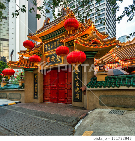 Traditional Kun Yam Thong Temple entrance with red lanterns contrasting modern skyscrapers, Kuala Lumpur, Malaysia. 131752945