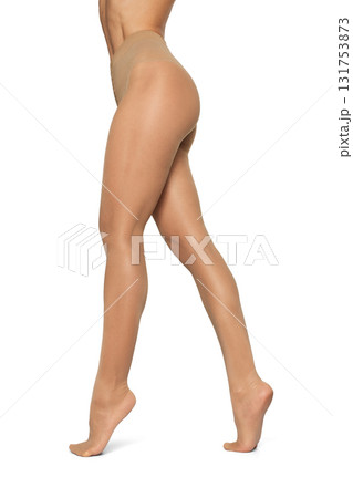 Beautiful long fit female legs in beige tights on white background 131753873