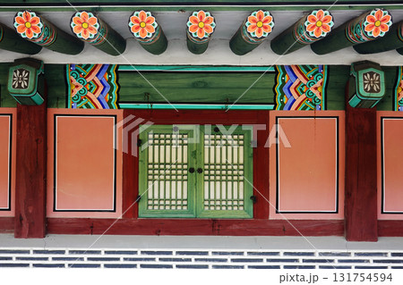 Traditional korean hanok colorful dancheong eaves with old wooden window detail Traditional korean hanok colorful dancheong eaves with old wooden window detail 131754594