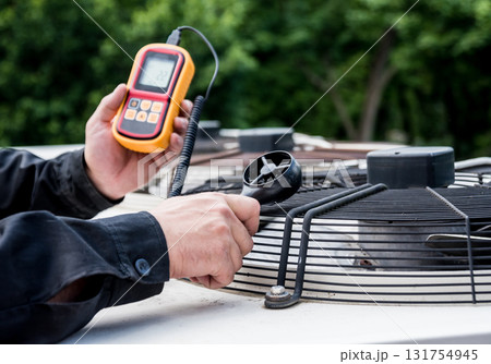 Technician use hand-held anemometer measuring air flowing measurement 131754945