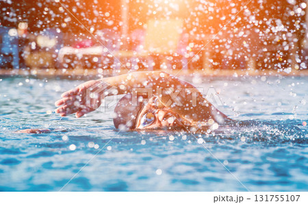 Young athletic man swimming in the swimming pool 131755107