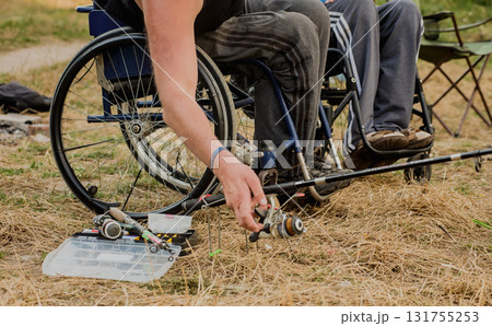 Handicapped men fishing at a lake. Wheelchair. Camping. 131755253