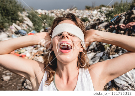 A blindfolded female volunteer screams from powerlessness in a dump of plastic A blindfolded female volunteer screams from powerlessness in a dump of plastic 131755312