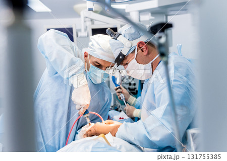 Spinal surgery. Group of surgeons in operating room with surgery equipment.  131755385