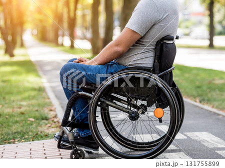 Handicapped man in wheelchair preparing to cross the road on pedestrian crossing 131755899