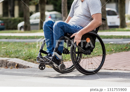 Handicapped man in wheelchair crossing street road Handicapped man in wheelchair crossing street road 131755900