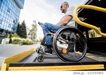 A man in a wheelchair on a lift of a vehicle for people with disabilities 131755903