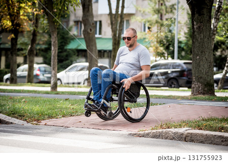 Handicapped man in wheelchair crossing street road 131755923