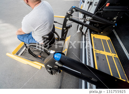A man in a wheelchair on a lift of a vehicle for people with disabilities 131755925