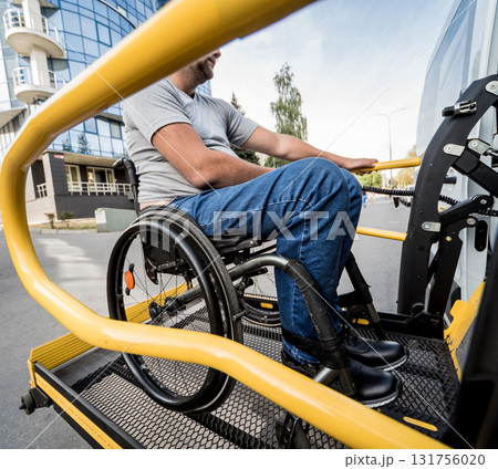 A man in a wheelchair on a lift of a vehicle for people with disabilities 131756020