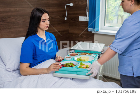 Nurse in medical coat is holding a tray with breakfast Nurse in medical coat is holding a tray with breakfast 131756198