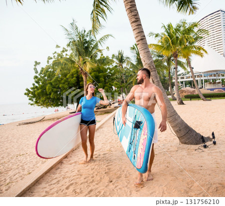 Two young surfers with boards on the beach Two young surfers with boards on the beach 131756210