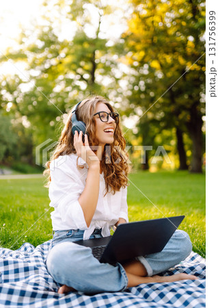 Portrait of woman sitting on green grass in park with legs crossed. Concept for education, business. Portrait of woman sitting on green grass in park with legs crossed. Concept for education, business. 131756399