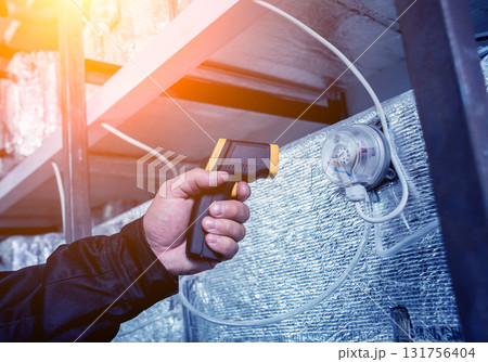 Technician use infrared thermal imaging camera to check temperature at fuse-box 131756404